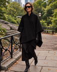 Noir black tweed wrap with fringe styled over a black dress